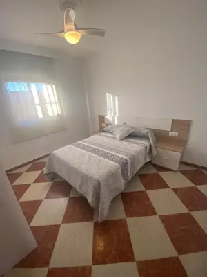 a bedroom with a bed and a checkered floor at Casa Silvia in Cádiz