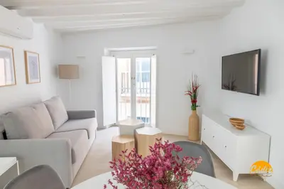 a white living room with a couch and a tv at Villalobos by Cadiz Time in Cádiz