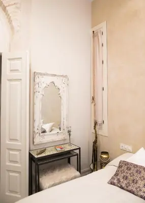 a bedroom with a bed and a mirror on the wall at innCádizPalacio Conde Casa-Brunet in Cádiz