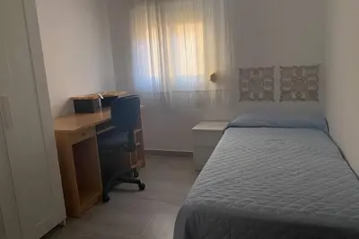 a bedroom with a bed and a desk and a deskablish at Love & Dream Beach Grupo AC Gestion in Cádiz