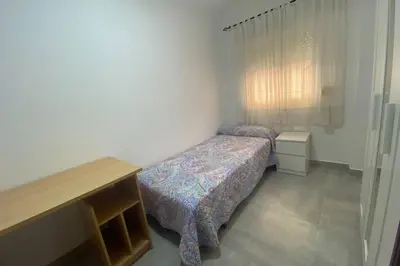 a small bedroom with two beds and a table at Love & Dream Beach Grupo AC Gestion in Cádiz