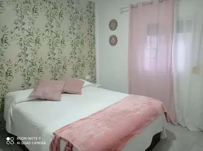 a bedroom with a bed with a pink blanket on it at Love & Dream Beach Grupo AC Gestion in Cádiz