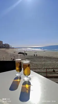 two glasses of beer sitting on a table at the beach at La Casa de Carmen Centro Historico , Free Parking in Cádiz