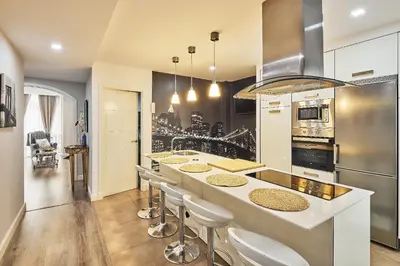 a kitchen with a counter with stools in it at La Casa de Carmen Centro Historico , Free Parking in Cádiz