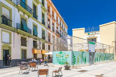a city street with chairs and tables and buildings at New Use Pz España in Cádiz