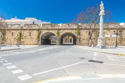 an empty street in front of a stone bridge at New Use Pz España in Cádiz