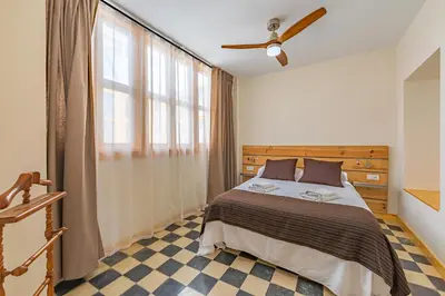 a bedroom with a bed and a ceiling fan at New Use Pz España in Cádiz