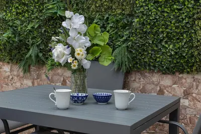 a table with two cups and a vase of flowers at Original Céntrico Bohemio in Jerez de la Frontera