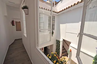 an empty balcony with a window and flowers at Original Céntrico Bohemio in Jerez de la Frontera
