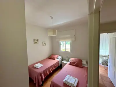 a room with two beds and a window at En la zona más tranquila del Novo Sancti Petri in Chiclana de la Frontera