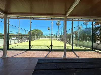 a tennis court seen through the windows of a tennis court at En la zona más tranquila del Novo Sancti Petri in Chiclana de la Frontera