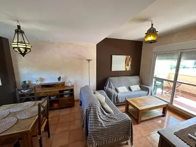a living room with a couch and a table at En la zona más tranquila del Novo Sancti Petri in Chiclana de la Frontera
