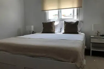 a bedroom with a large bed with a window at ÁTICO EN EL CENTRO, terraza 20 m2, garaje, Wi-Fi, AC in Sanlúcar de Barrameda