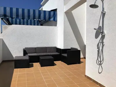 a living room with a couch and a shower at ÁTICO EN EL CENTRO, terraza 20 m2, garaje, Wi-Fi, AC in Sanlúcar de Barrameda