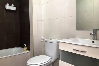 a white bathroom with a toilet and a sink at ÁTICO EN EL CENTRO, terraza 20 m2, garaje, Wi-Fi, AC in Sanlúcar de Barrameda
