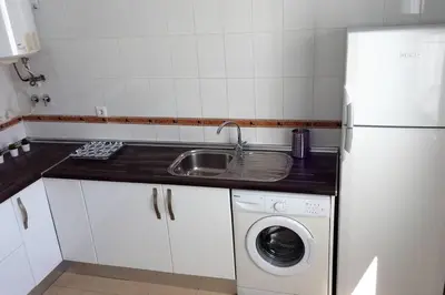 a small kitchen with a sink and a refrigerator at ÁTICO EN EL CENTRO, terraza 20 m2, garaje, Wi-Fi, AC in Sanlúcar de Barrameda