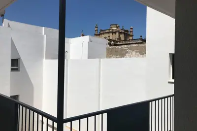 a view of a building through a window at ÁTICO EN EL CENTRO, terraza 20 m2, garaje, Wi-Fi, AC in Sanlúcar de Barrameda