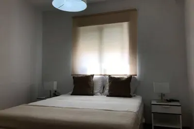 a bedroom with a large bed with a window at ÁTICO EN EL CENTRO, terraza 20 m2, garaje, Wi-Fi, AC in Sanlúcar de Barrameda
