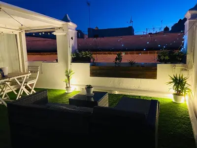 a room with a table and a chair on a balcony at Ático Cádiz Suite in Cádiz