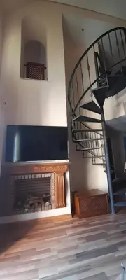 a living room with a fireplace and a spiral staircase at Apartamento S. Fernando bahia sur in San Fernando