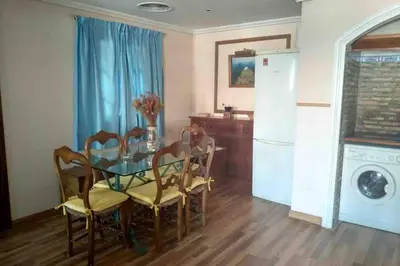 a dining room with a table and chairs and a kitchen at Apartamento S. Fernando bahia sur in San Fernando