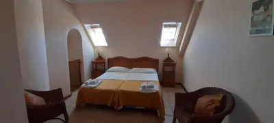 a bedroom with a bed and two chairs and two windows at Apartamento S. Fernando bahia sur in San Fernando