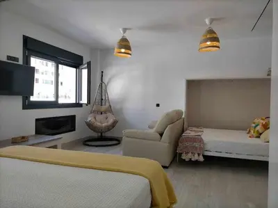 a living room with a bed and a couch at Acogedor apartamento en la playa de Cádiz in Cádiz