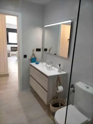 a bathroom with a sink and a mirror and a toilet at Acogedor apartamento en la playa de Cádiz in Cádiz
