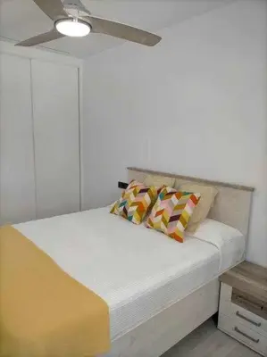 a bed with two pillows on it in a room at Acogedor apartamento en la playa de Cádiz in Cádiz