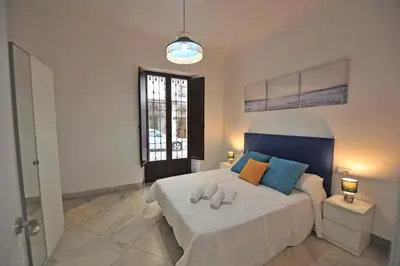 a bedroom with a bed with two towels on it at Palacete Centro Duque de Valais in Jerez de la Frontera