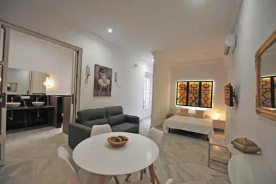 a living room with a table and a couch at Palacete Centro Duque de Valais in Jerez de la Frontera