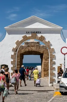 a group of people walking through a stone archway at Casa Patio La Viña by Cadiz Time in Cádiz