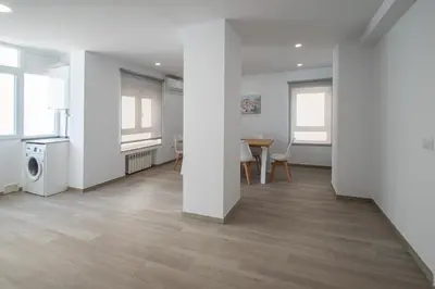 a living room with white walls and a table and chairs at Nuevo Mirandilla Apartment - Cadiz Beach in Cádiz