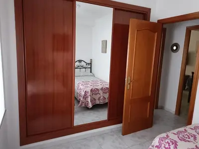 a glass door leading to a bedroom with a bed at Apartamento Candari Playa en Cadiz in Cádiz