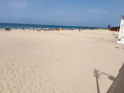 a sandy beach with a lifeguard tower on it at Apartamento Candari Playa en Cadiz in Cádiz
