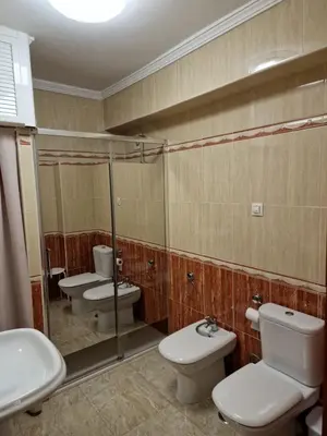 a bathroom with two toilets and two sinks at Apartamento Candari Playa en Cadiz in Cádiz