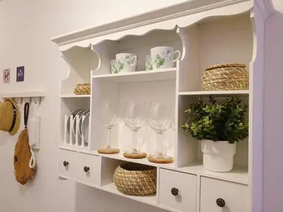 a white cabinet with wine glasses and a plant at Sherryflat Estudio- Parking, in Jerez de la Frontera