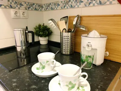 a kitchen counter with two white cups and saucers at Sherryflat Estudio- Parking, in Jerez de la Frontera