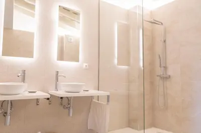 a bathroom with two sinks and a shower at Suites Alfonso X in Jerez de la Frontera