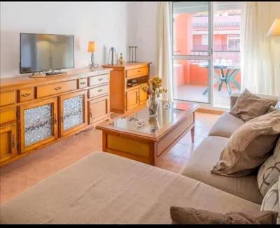 a living room with a couch and a tv at Apartamento Vista Hermosa en Punta Candor con piscina y Wifi in Rota