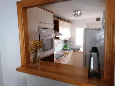 a kitchen with white appliances and a wooden counter top at Apartamento Vista Hermosa en Punta Candor con piscina y Wifi in Rota