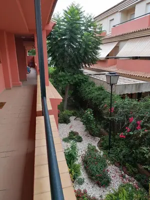 a corridor of a building with a flower garden at Apartamento Vista Hermosa en Punta Candor con piscina y Wifi in Rota