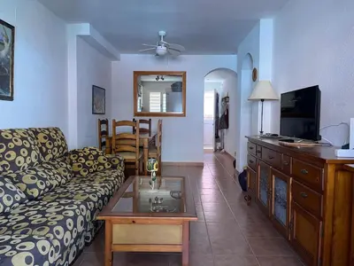 a living room with a couch and a table at Apartamento Vista Hermosa en Punta Candor con piscina y Wifi in Rota