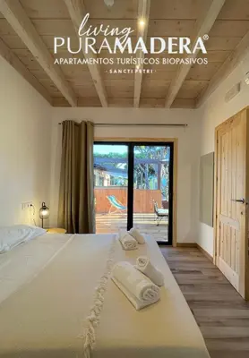 a bedroom with a large bed with towels on it at Apartamentos Biopasivos Living Pura Madera in Chiclana de la Frontera