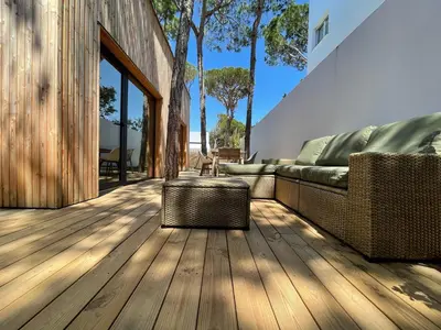 a living room with a couch on a wooden deck at Apartamentos Biopasivos Living Pura Madera in Chiclana de la Frontera