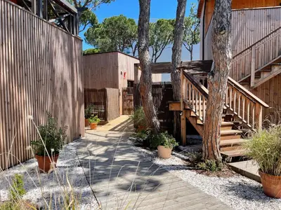 a house with wooden stairs and trees in a yard at Apartamentos Biopasivos Living Pura Madera in Chiclana de la Frontera