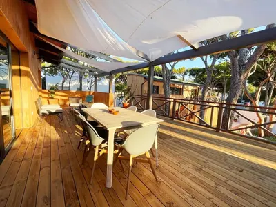 a patio with a table and chairs on a deck at Apartamentos Biopasivos Living Pura Madera in Chiclana de la Frontera