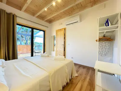 a bedroom with a large white bed and a window at Apartamentos Biopasivos Living Pura Madera in Chiclana de la Frontera