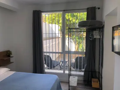 a bedroom with a bed and a door to a balcony at La Estación in Sanlúcar de Barrameda