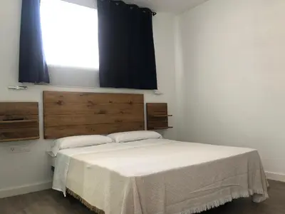 a bedroom with a large bed with a window at La Estación in Sanlúcar de Barrameda